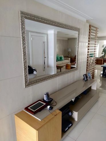Espelho grande com moldura detalhada na sala moderna.