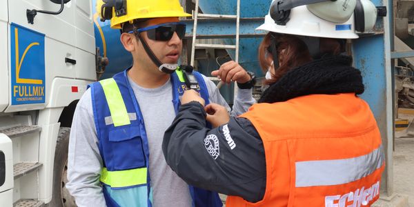 Two construction workers preparing safety gear at a site.