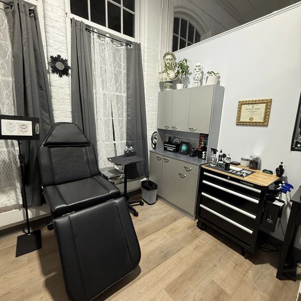 Modern treatment room with black recliner and storage units.