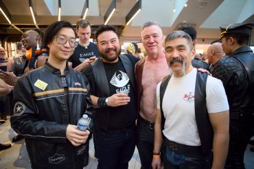 Group of friends posing and smiling at an indoor event.
