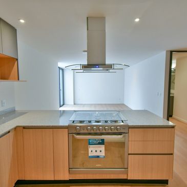 Cocina moderna con estufa y campana extractora.