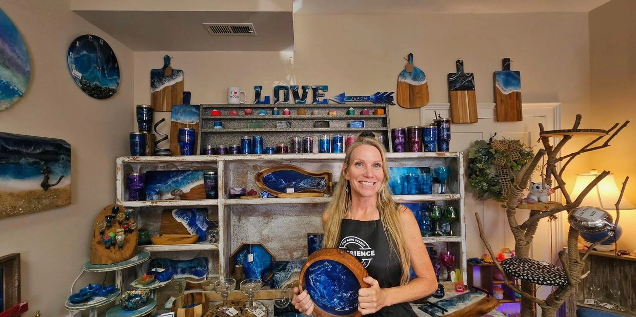 Melinda Rhodes, founder and owner of Millie J's, displaying her handcrafted wood and resin art.