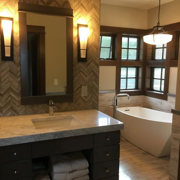 Modern bathroom with a marble countertop and freestanding tub.