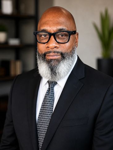 Professional man in a suit with glasses and a gray beard.