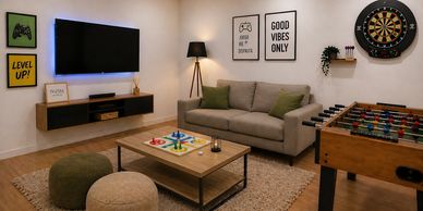 Cozy game room with sofa, foosball table, and dartboard.