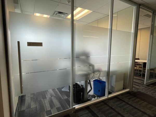 Office entrance with frosted glass doors and nameplate.