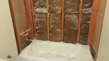 Bathroom under renovation with exposed insulation.