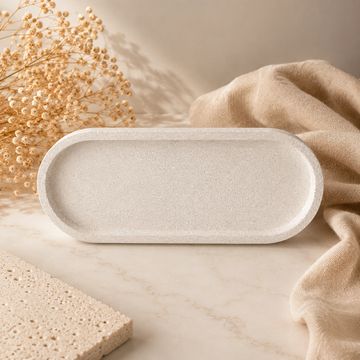 Bandeja oval beige con textura y elementos decorativos.