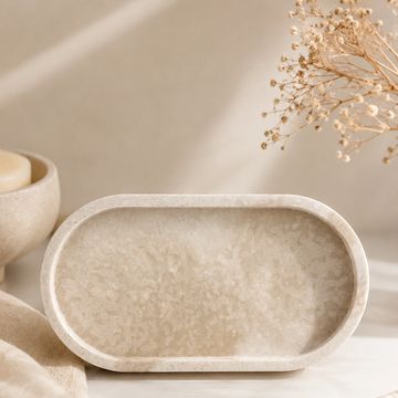 Bandeja decorativa beige en superficie clara.