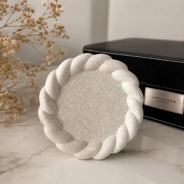 Plato blanco decorativo con borde trenzado.