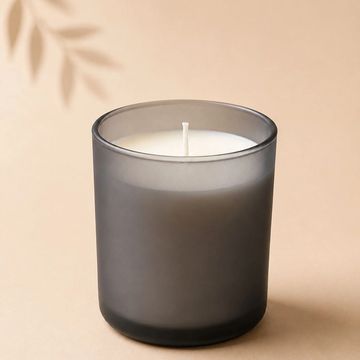 Vela blanca en recipiente gris mate.