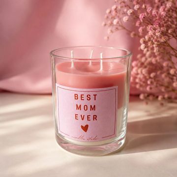 Vela rosa con mensaje "Best Mom Ever" y flores rosas.