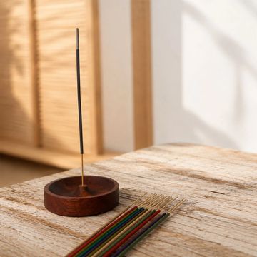 Incienso encendido en soporte de madera.
