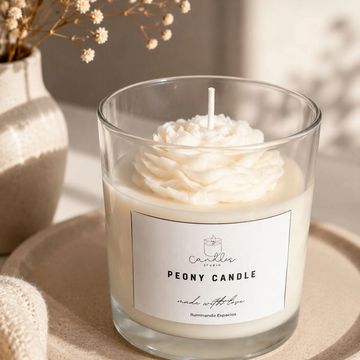 Vela blanca en vaso de vidrio con diseño de peonía.
