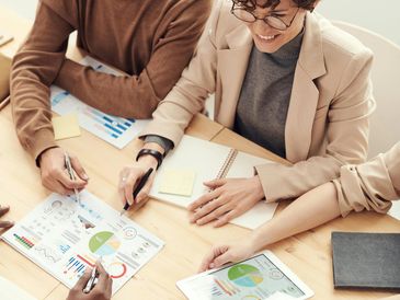 Team collaborating over business charts and data at a meeting table.