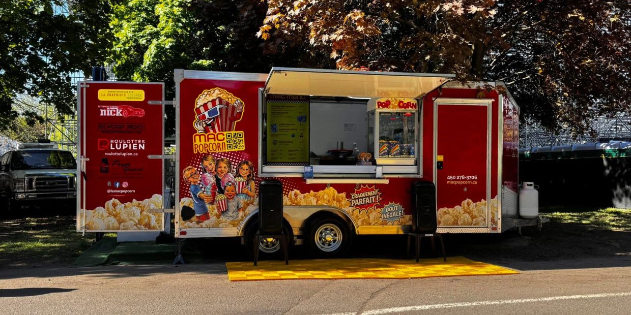Camion de popcorn rouge avec illustrations festives.