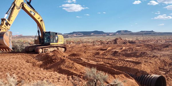 A piece of construction equipment moving dirt.