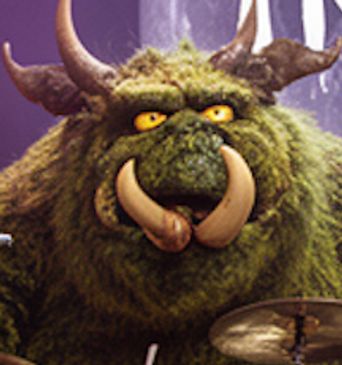 A large green furry monster with yellow eyes and big tusks.
