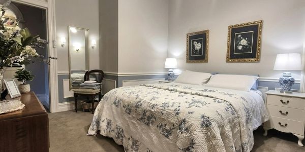 Cozy bedroom with floral bedding and bedside lamps.