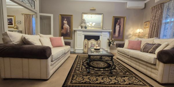 Elegant living room with two sofas and ornate rug.