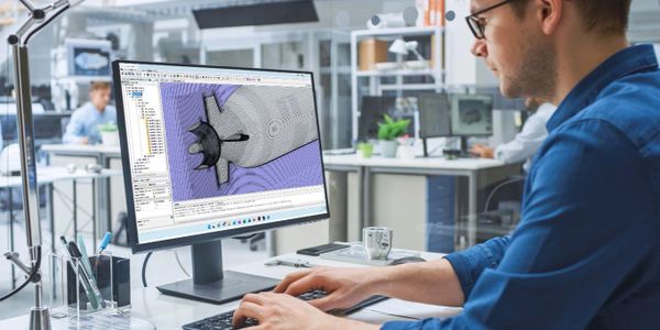Man working on 3D design software in a modern office.