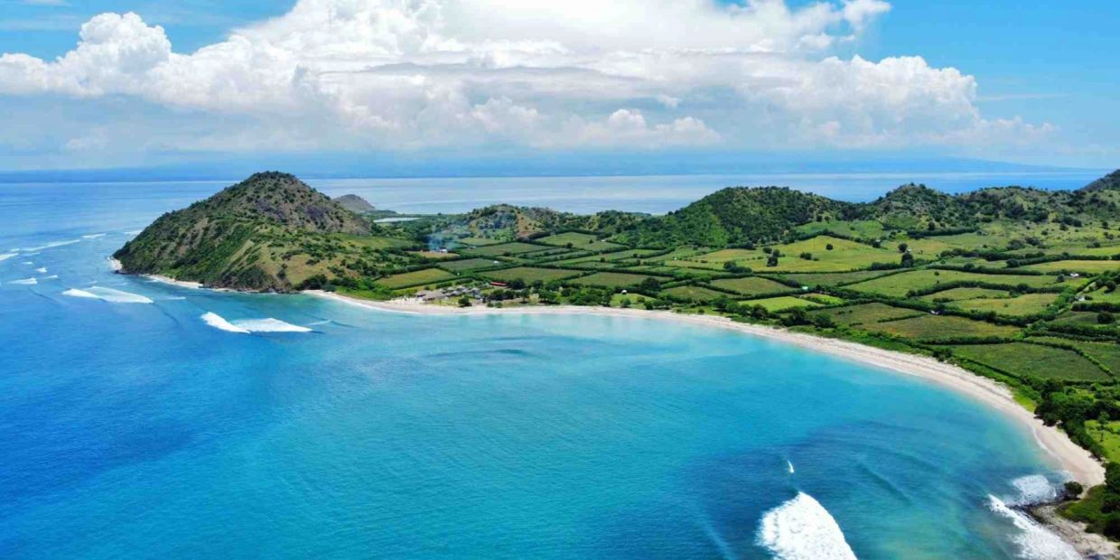 Scenic coastal landscape with blue water and green hills.