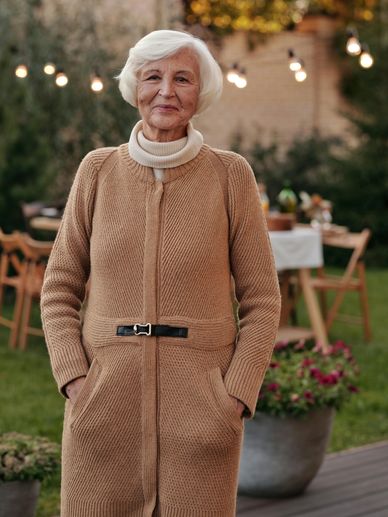 A picture of an old woman standing in the garden