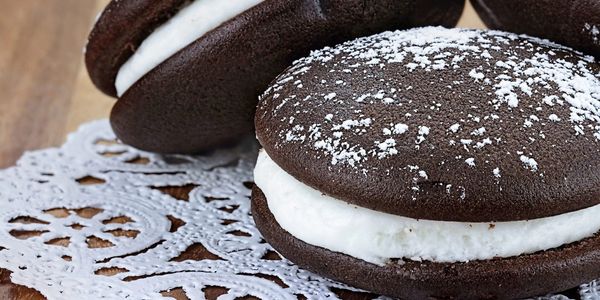 Chocolate sandwich cookies with cream filling and powdered sugar on top.