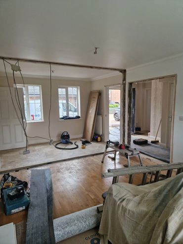 Interior of a house under renovation with exposed wiring and tools.
