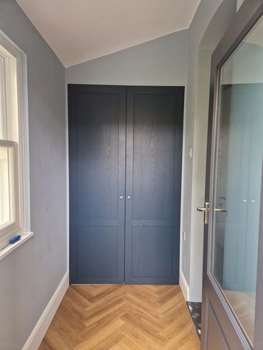 A small area made into a utility room by sectioning the room off with some fitted doors.
