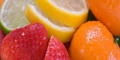 Close-up of various fresh fruits including strawberry, lime, lemon, and orange.