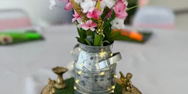 Decorative flower vase with fairylights on a table.