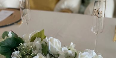 Wedding table decoration with white flowers and champagne glasses.