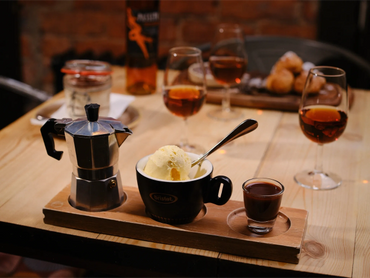 Espresso set with ice cream and coffee maker on a wooden tray.