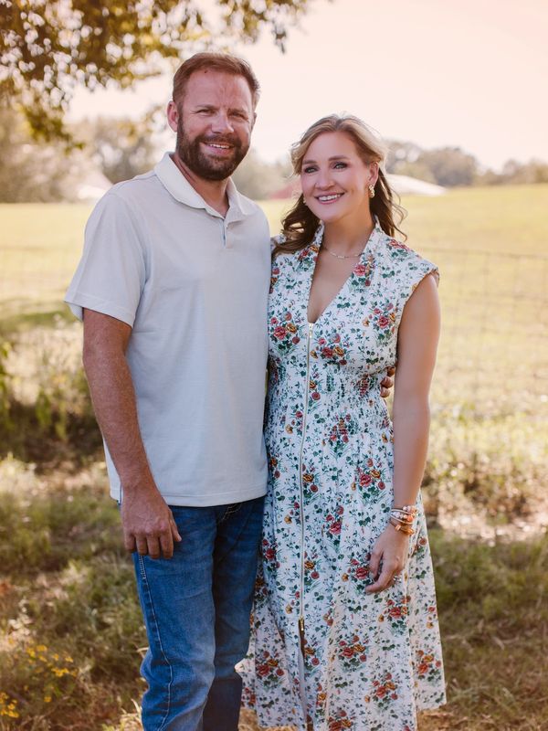 Smiling couple posing outdoors in daylight.