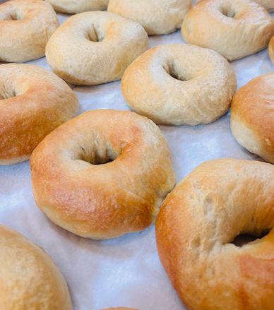 Freshly baked bagels on parchment paper.