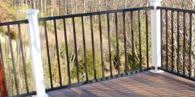 Black aluminum  railing between white composite posts showcases one of the styles built by EZ Deck 
