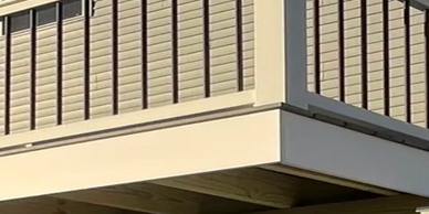 A Trex composite deck with white PVC trim, grey decking, white railing and black balusters 