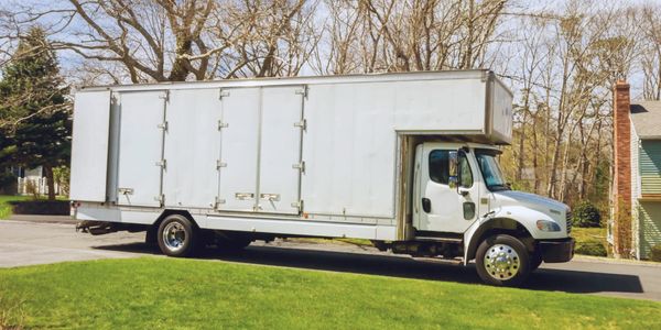 A large white moving truck parked on a suburban street.