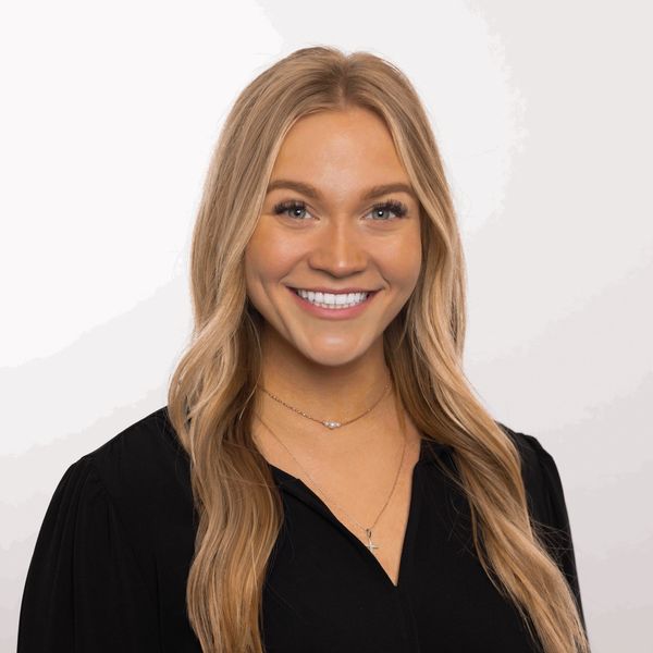 Smiling woman with long blonde hair wearing a black top.