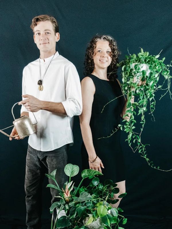 Dan (on the left) and Laura (on the right) holding plants. 