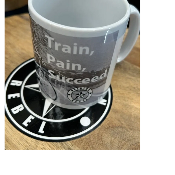 A custom Peloton Rebel mug placed on a wooden stool.