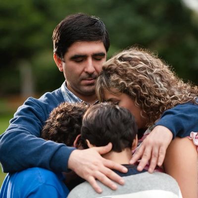 Father and wife and children in a circular embrace