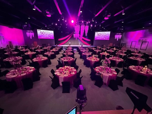 Elegant banquet hall lit with purple lighting for a formal event.