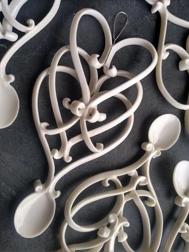 White decorative spoons with heart designs.