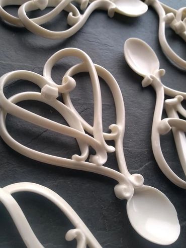 Decorative white plastic spoons with intricate handles.