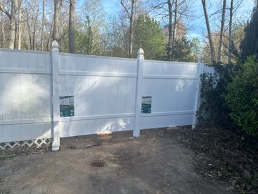 White vinyl fence with two small pet doors installed.