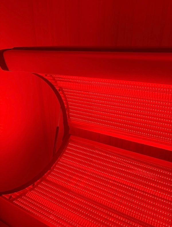 Close-up of a red-lit tanning bed with LED lights.