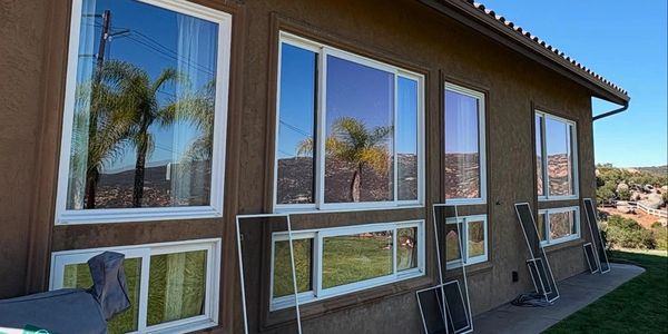 House exterior with multiple large windows and detached window screens.