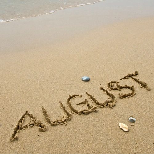August written in the sand at a beach